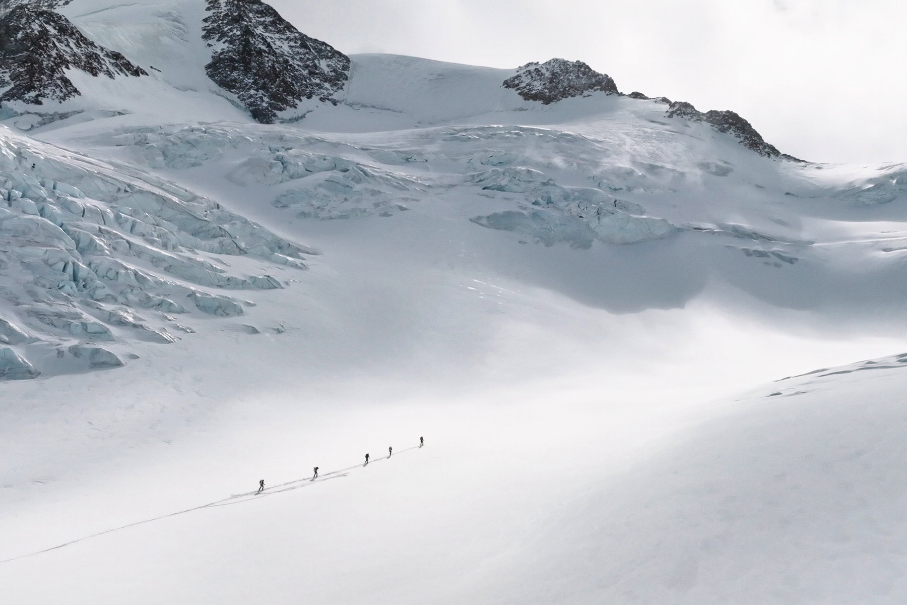 Sobald der Aufstieg am Gletscher beginnt, ist der Aufbau der Wildspitze schon im Blick. Hier ragt sie links aus dem Foto hinaus. Die Spur führt rechts aus dem Bild hinaus, in einem weiten Bogen um die Spalten herum. Foto: Mountain Tribe