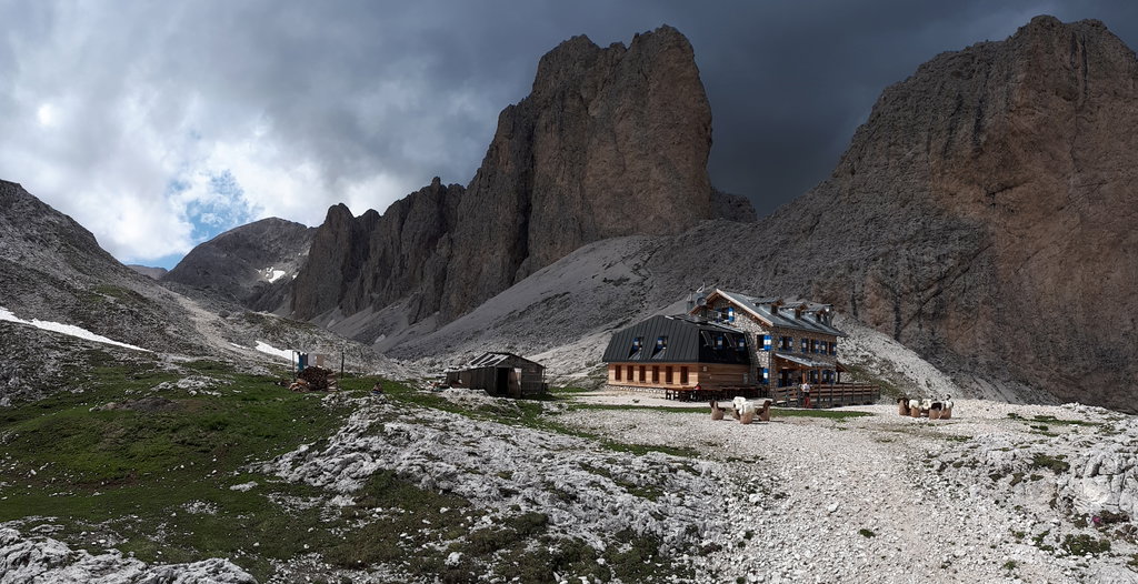 Die Antermoia Hütte in der Sonne, während sich hinter den Felstürmen dunkle Wolken aufstauen. Es bleibt aber trocken. Foto: Konrad Gwiggner