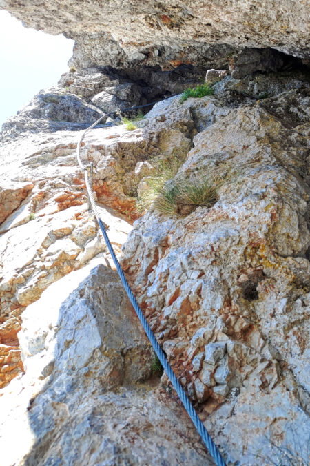 Der Steig führt durch eine Höhle auf die Preinerwandplatte (links), auf welcher ein Spreizschritt über eine kleine Kluft zu bewältigen ist (rechts) 1. Foto: Simon Widy