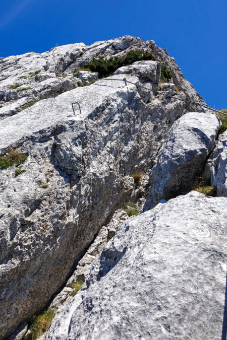 Der Steig führt durch eine Höhle auf die Preinerwandplatte (links), auf welcher ein Spreizschritt über eine kleine Kluft zu bewältigen ist (rechts) 2. Foto: Simon Widy