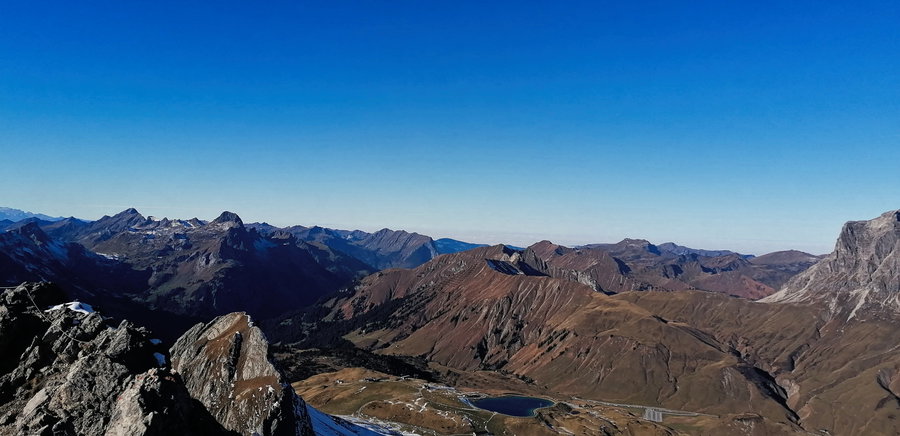 Aufstiegsweg vom Gipfel aus: mittig Speichersee, rechts davon der Parkplatz am Hochtannbergpass. Foto: Norman und Lisa