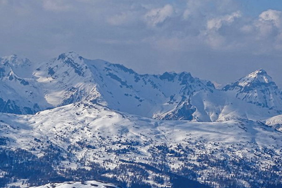 Das Kalbenjoch links des von Lawinenverbauungen gesäumten Hangs der Peilspitze, noch weiter links die Kesselspitze. Im Vordergrund der Eggerberg mit abgeblasenem Gipfel. Foto: Protect Our Winters Austria