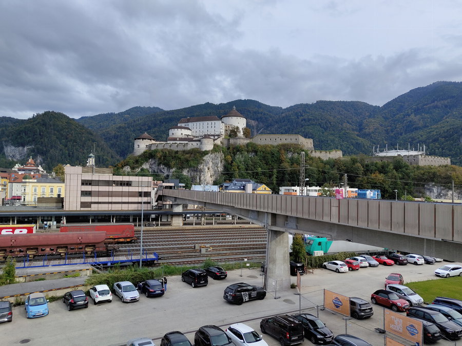 Über die Fußgängerbrücke wird der Bahnhof überquert, im Hintergrund die Festung Kufstein; Foto: Simon Widy