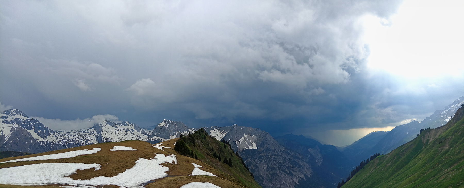 Hüttenausblick mit nahendem Gewitter: links das verschneite Lechquellgebiet, rechts das Walsertal. Foto: Norman und Lisa