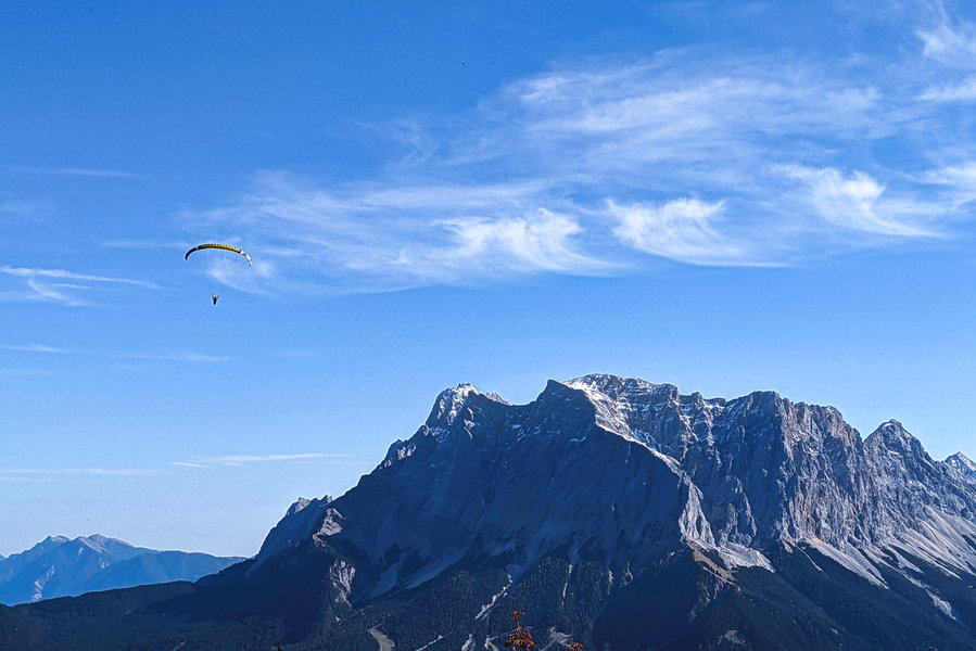 Bei der kurzen Suche nach dem Weg hinter der Skihütte bleibt mal wieder Zeit, die herrliche Aussicht in Richtung Zugspitze zu genießen. Und siehe da, es genießt wohl noch ein Mensch die Aussicht, aber aus der Vogelperspektive! Foto: Thomas Obermair