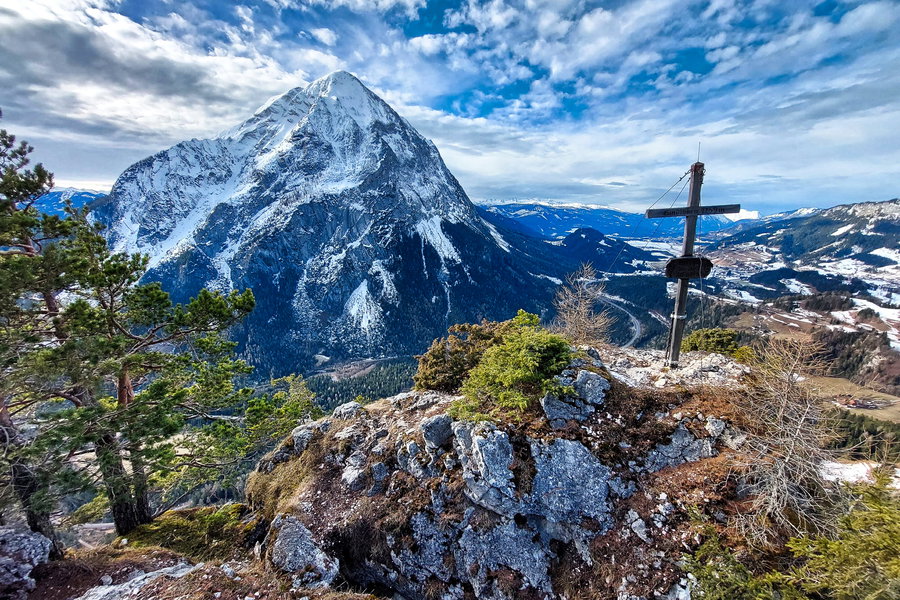 Gipfelkreuz Gindlhorn auf eigenem kleinen Felsen mit Grimming im Hintergrund. Foto: Alice Frischherz