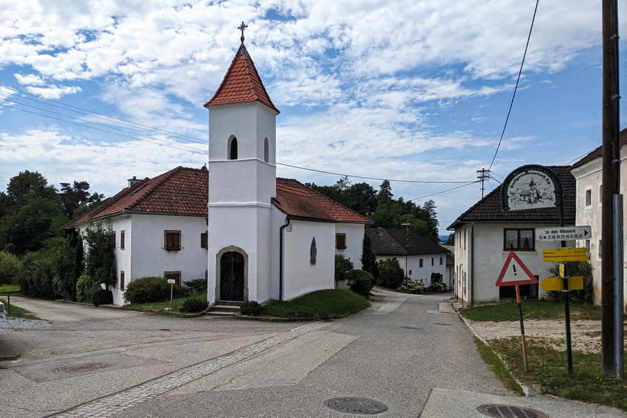 Ein schöner Hof im Hintergrund, die Kapelle im Vordergrund und rechts im Bild die Wanderschilder, die uns den Weg weisen. Foto: Thomas Obermair