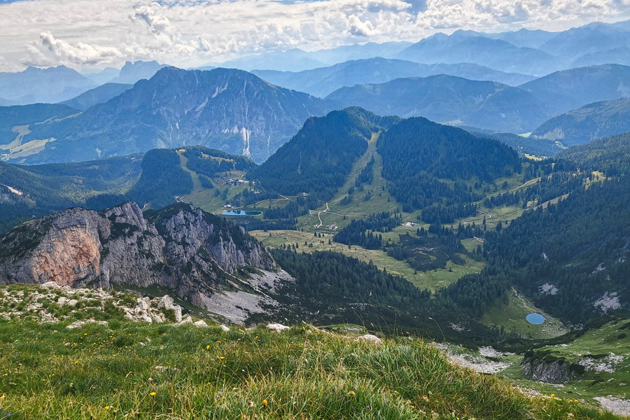 Die Rote Wand macht ihrem Namen alle Ehre und lacht uns schon aus der Entfernung entgegen. Hier sieht man außerdem gut auf die Wurzeralm mit ihren Skipistentrassen. Neben dem Brunnsteiner See (rechts vorne) ist auch der Speichersee ein Blickfang. Foto: Anna, POW AT