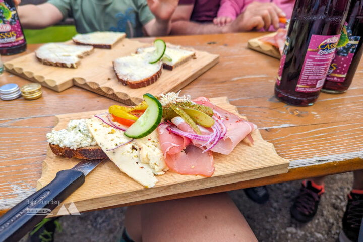 Oben auf der Alm angekommen, mit Brotzeit, Kühen und Blick Richtung Berchtesgaden. Foto: Maresa Brandner