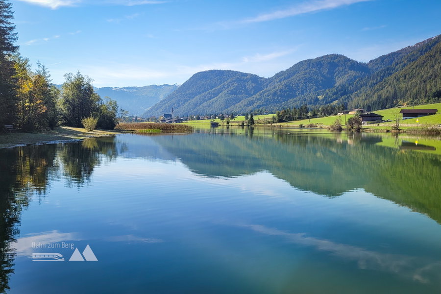 Der Pillersee mit dem Hauptort St. Ulrich. Im Hintergrund die Buchensteinwand mit dem größten Gipfelkreuz der Welt. Foto: Konrad Gwiggner