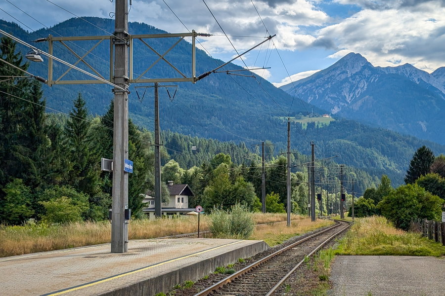 Bahnhof Greifenburg-Weissensee mit Blick zurück auf die große Wiese bei Egg und Spitzkofel (2.233m) im Hintergrund. Foto: Martin Heppner