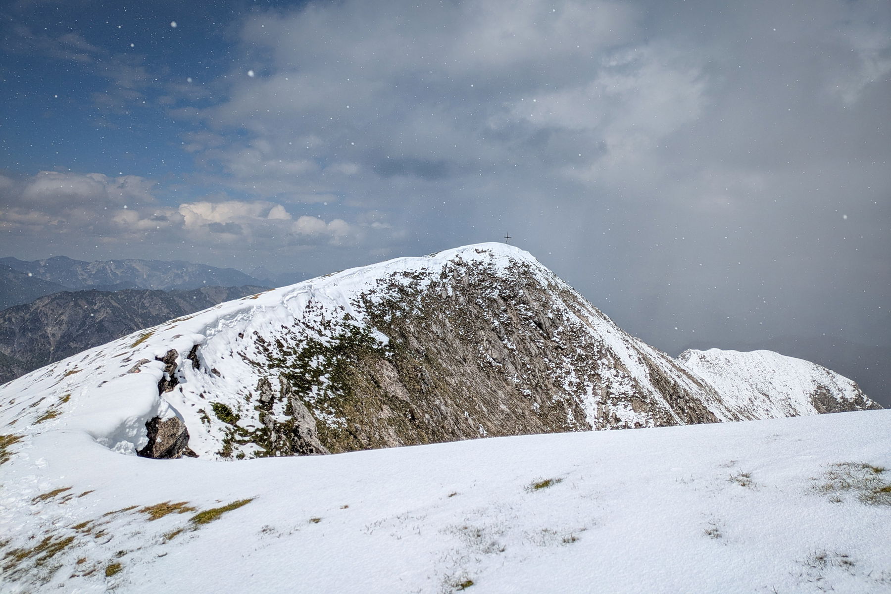 Graupelschauer bei Sonnenschein. Blick zurück auf den Gipfel. Die Schneewechte ist das letzte Relikt aus dem außerordentlich schneearmen Winter 2024/25. Foto: Anna, POW AT